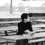 reading a paperback book on a park bench before a solo trip